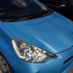 Front of a light blue Toyota Aqua: bonnet and right headlight